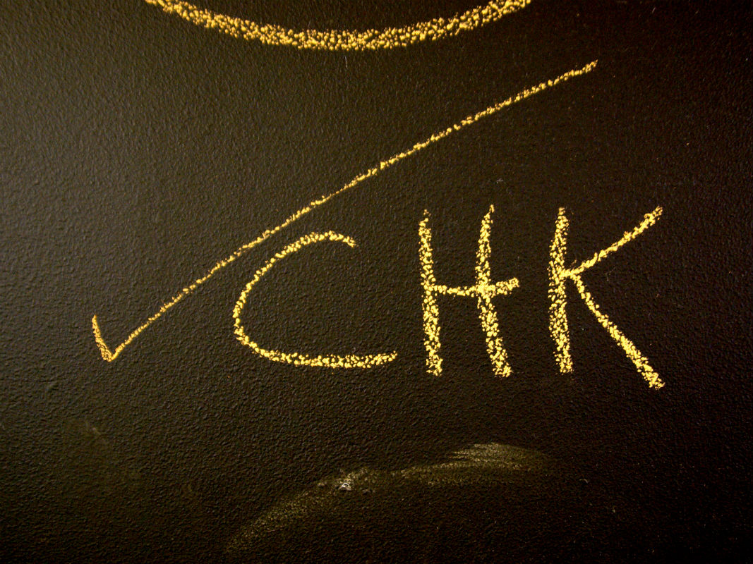 Checkmark with word 'chk' on blackboard